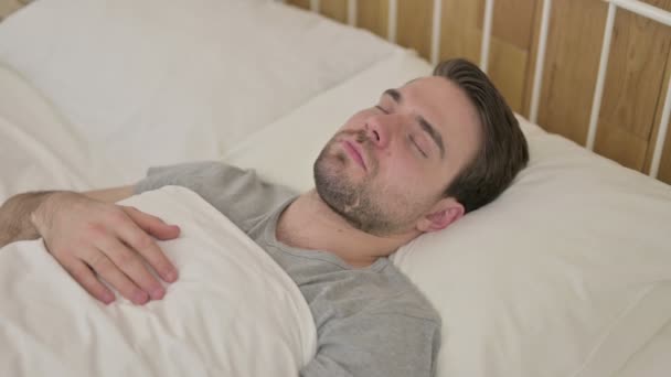 Cansado barba jovem homem ter sesta na cama — Vídeo de Stock