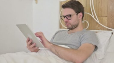 Yatakta Tablette Başarı Kutlaması Yapan Sakallı Genç Adam