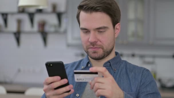 Portrait du jeune homme barbu utilisant la carte de crédit sur Smartphone — Video