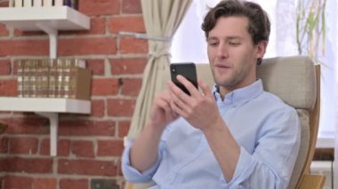 Genç adam Smartphone 'da Video Sohbeti yapıyor