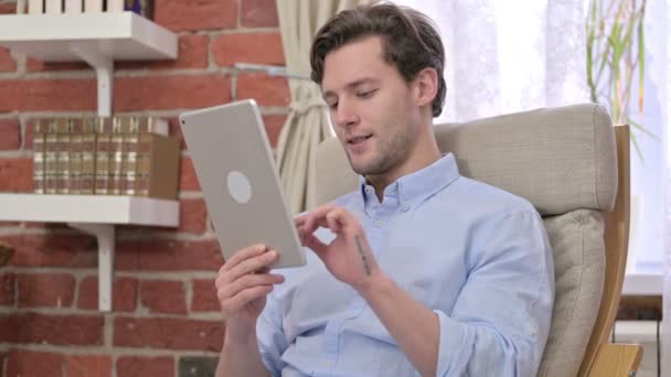 Νεαρός άνδρας χρησιμοποιώντας tablet στο σύγχρονο γραφείο — Αρχείο Βίντεο