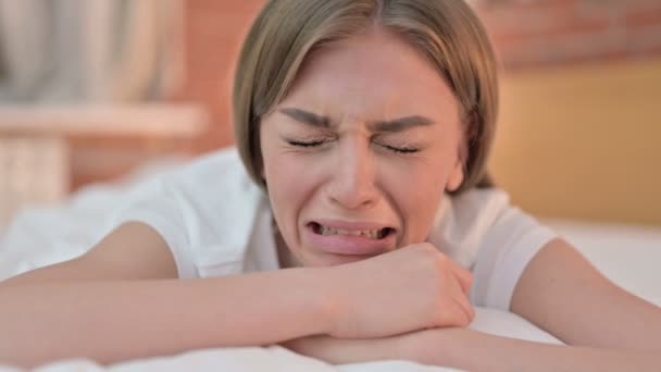 Close-up van mooi jong vrouw huilen in bed — Stockvideo