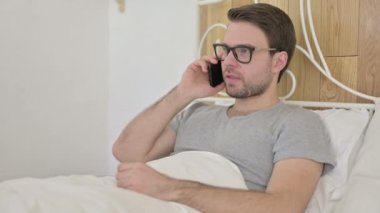 Yatakta Sakallı Genç Adam Akıllı Telefonla Konuşuyor