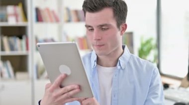 Tablet Bilgisayarında Başarıyı Kutlayan Genç Adam