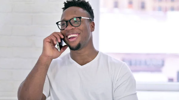 Retrato del alegre hombre africano casual que habla en el teléfono inteligente —  Fotos de Stock