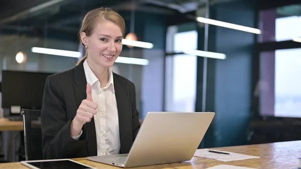 Молодая предпринимательница, работающая с большими пальцами в офисе — стоковое фото