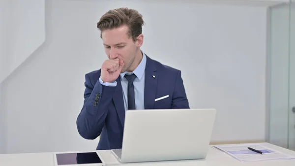 Doente jovem empresário trabalhando no laptop e tosse — Fotografia de Stock