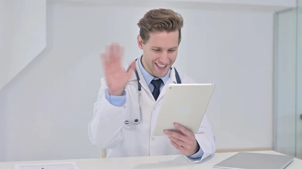 Young Male Doctor doing Video Chat on Tablet in Clinic — Stock Photo, Image