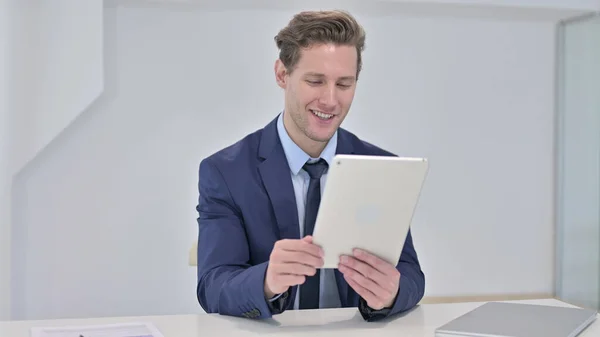 Gelukkig jong zakenman kijken video op tablet — Stockfoto
