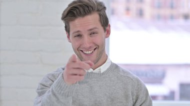 Kamerayı gösteren neşeli genç adamın portresi.