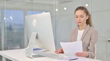 Genç İşkadını Ofiste Belgeleri Okuyor