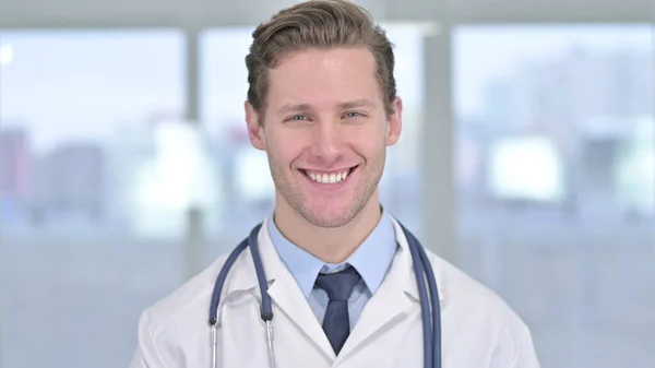 Portret van lachende jonge mannelijke arts kijkend naar camera — Stockfoto
