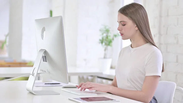 Giovane donna che lavora sul desktop in ufficio — Foto Stock