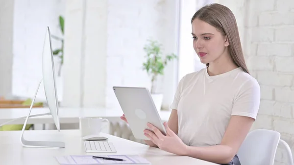 Hermosa mujer joven usando la tableta en la oficina moderna — Foto de Stock