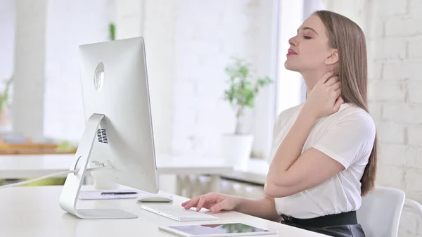 Giovane donna che ha dolore al collo in ufficio — Foto Stock