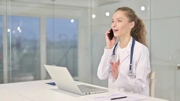 Ung kvinnlig doktor talar på smartphone — Stockfoto