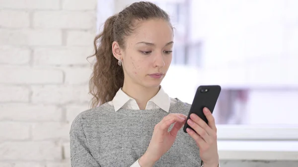 Ritratto di giovane donna latina concentrata con smartphone — Foto Stock