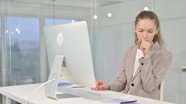 Больная молодая белая предпринимательница кашляет в офисе — стоковое фото