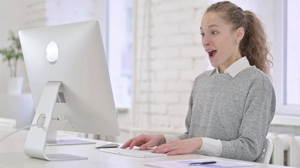 Jeune femme latine célébrant le succès sur le bureau au bureau — Photo