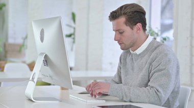 Masaüstünde Çalışan Odaklanmış Yaratıcı Genç Adam