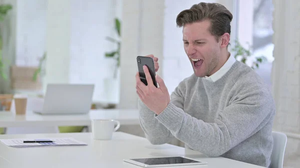 Creative Young Man Celebrating Success on Smartphone — Stock Photo, Image