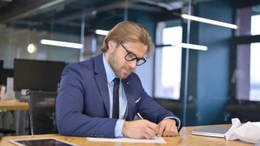 Öfkeli İşadamı Ofis Masasında Belgeler Yazıyor