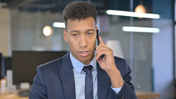 Retrato de un joven empresario hablando por teléfono inteligente en la oficina —  Fotos de Stock