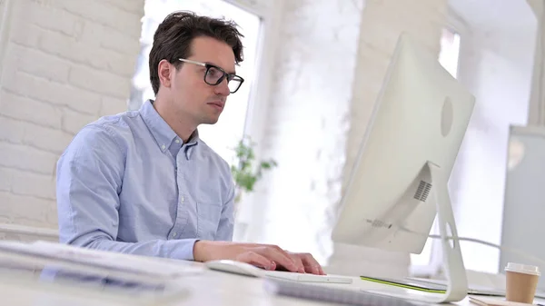 Lavorare giovane utilizzando il computer portatile in ufficio moderno — Foto Stock