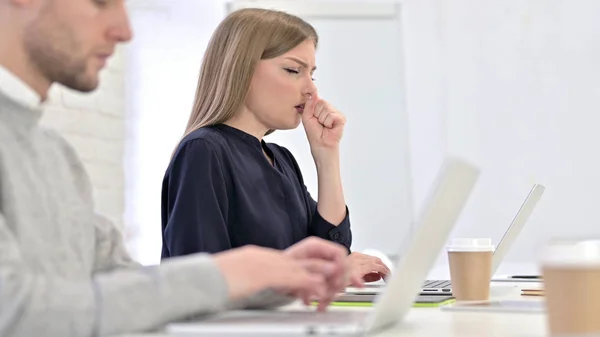 Mulher criativa trabalhando no laptop e tosse no escritório — Fotografia de Stock