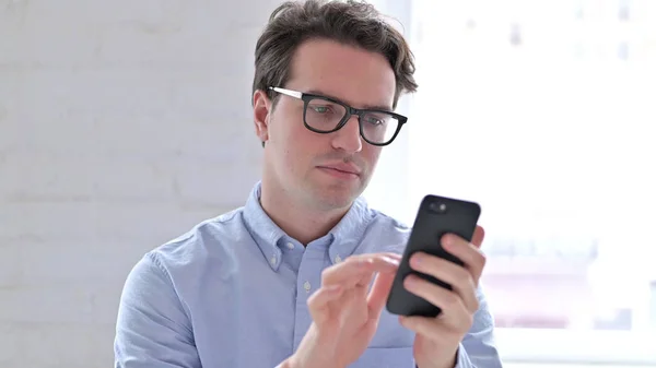 Portrait de jeune homme détendu utilisant un smartphone — Photo