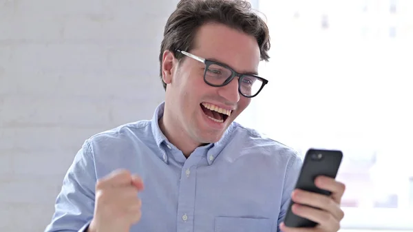 Portrait of Young Man Celebrating Success on Smartphone — Stock Photo, Image