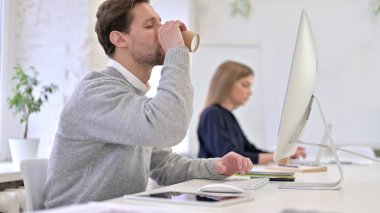 Kahve İçen ve Masaüstünde Çalışan Adam