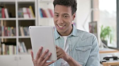 Smiling Young African American Man using Digital Tablet