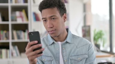 Young African American Man using Smartphone, Browsing Internet 