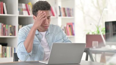 Stressed Young African American Man having Headache at Work 