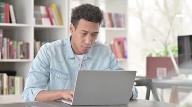 Working Young African American Man in Shock Looking at Camera