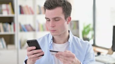Credit Card used on Smartphone by Young Man