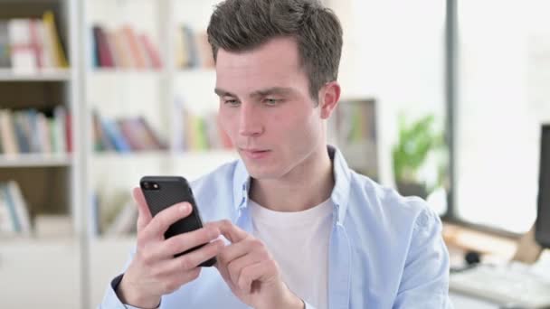 Rozrušený mladý muž dostat šok na Smartphone — Stock video