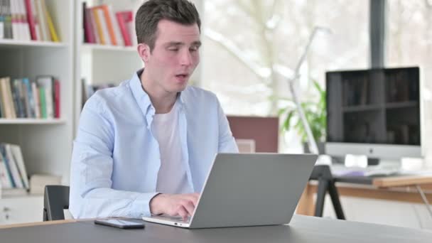 Молодий чоловік кашляє працює на ноутбуці — стокове відео