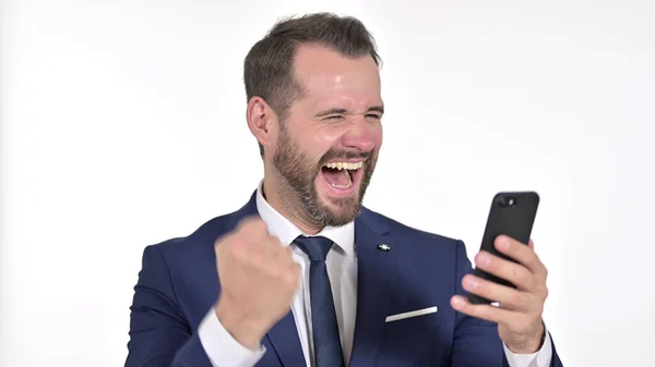 Portrait de joyeux jeune homme d'affaires célébrant sur Smartphone, fond blanc — Photo