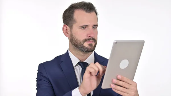 Portret van een serieuze jonge zakenman met behulp van tablet, witte achtergrond — Stockfoto