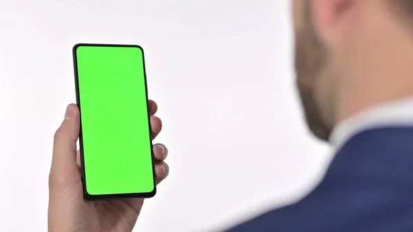 Achteraanzicht van Zakenman op zoek naar Smartphone met Chroma Screen, Witte achtergrond — Stockfoto