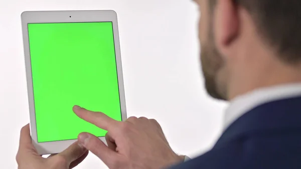 Achteraanzicht van zakenman met behulp van tablet met chroma scherm, witte achtergrond — Stockfoto