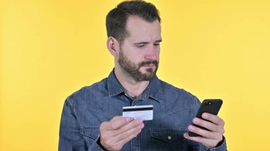 Online Payment on Smartphone by Young Man, Yellow Background