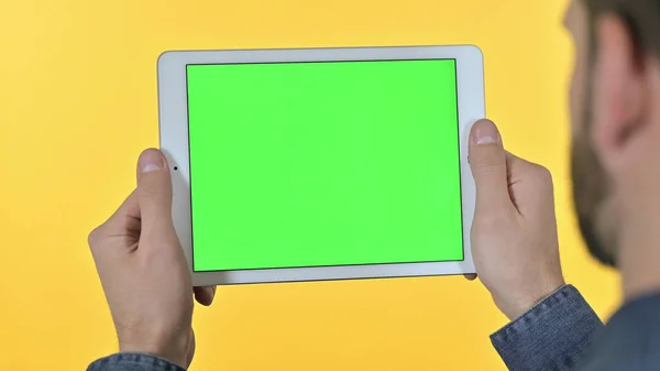 Genç Tasarımcının Arka Görünümü Tablete Krom Ekran, Sarı Arkaplan ile Bakıyor — Stok fotoğraf