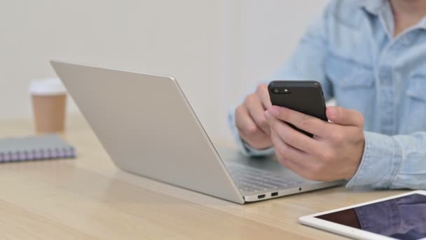 Χρήση Smartphone από Man with Laptop, Κοντινό πλάνο — Αρχείο Βίντεο