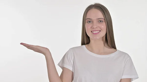 Jovem mulher apresentando produto na mão, fundo branco — Fotografia de Stock