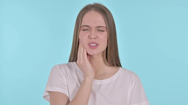 Retrato de una hermosa mujer joven con dolor de muelas, fondo azul — Foto de Stock