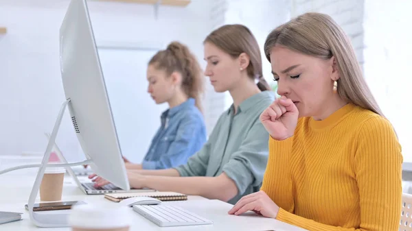 Jonge vrouw werkt op Desktop en hoesten — Stockfoto