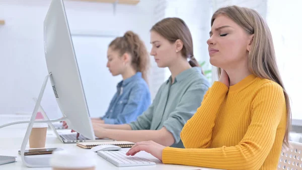 Junge kreative Frau arbeitet am Desktop und hat Nackenschmerzen — Stockfoto